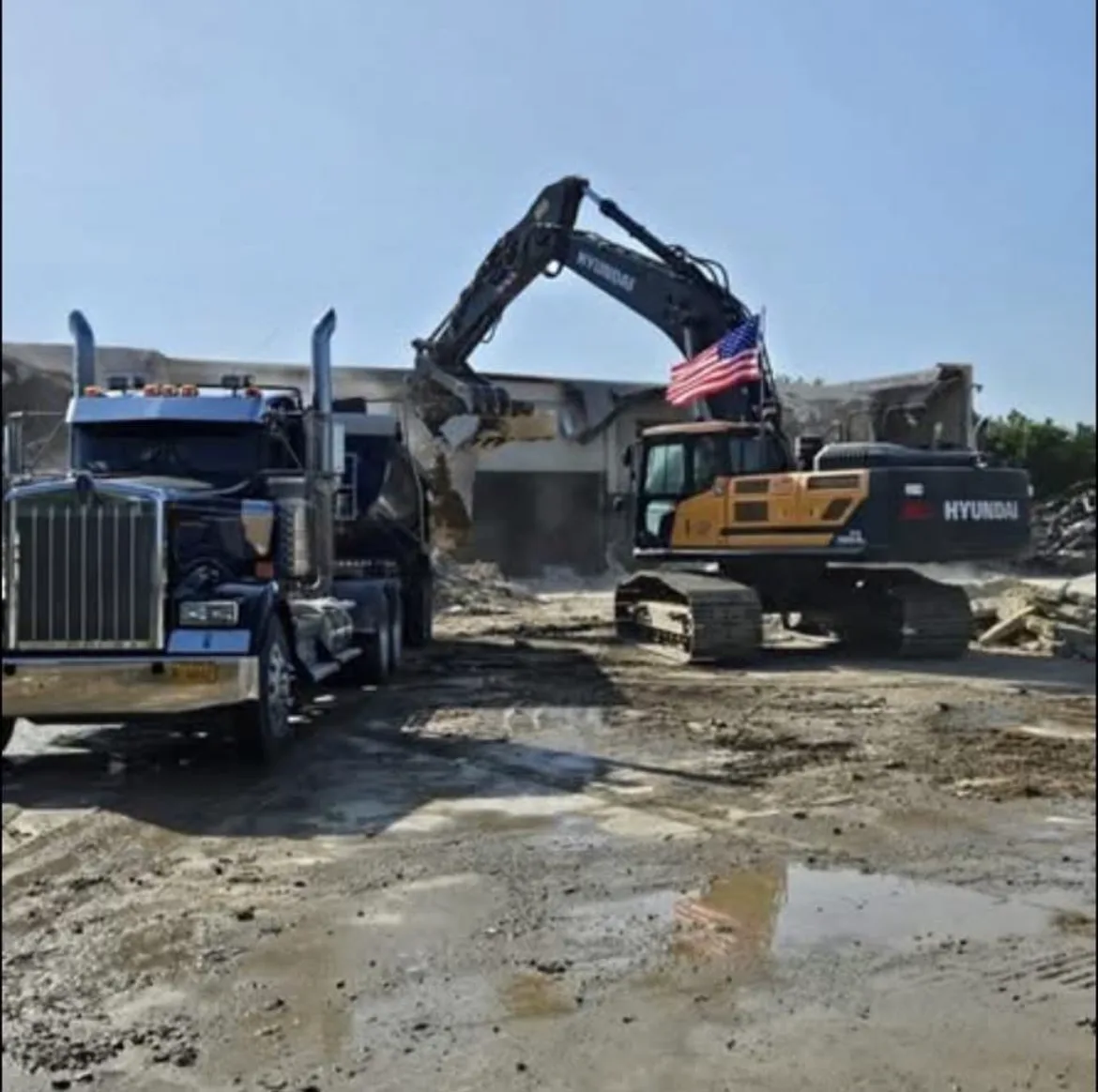 Excavator and truck working a large commercial demolition